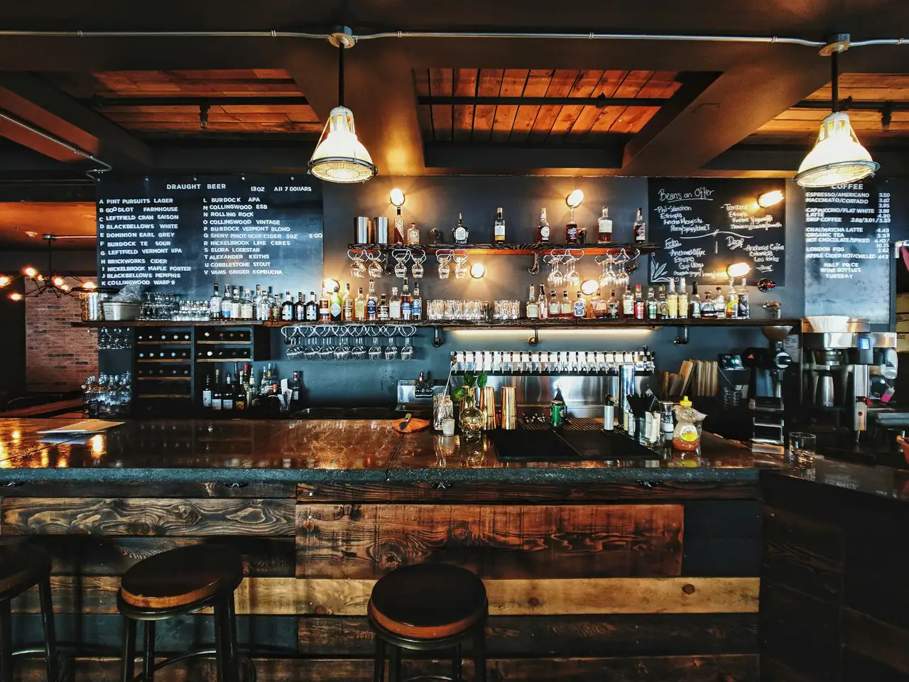 Bar met tapkranen, flessen op een schap en barkrukken
